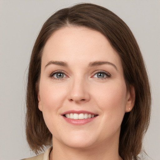 Joyful white young-adult female with medium  brown hair and grey eyes