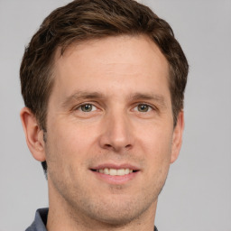 Joyful white adult male with short  brown hair and grey eyes