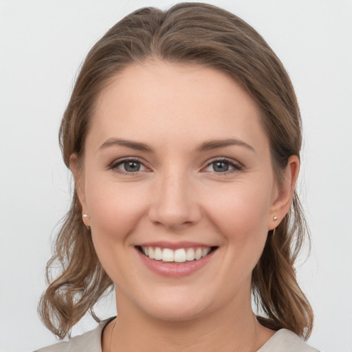 Joyful white young-adult female with medium  brown hair and grey eyes