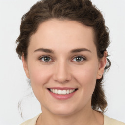 Joyful white young-adult female with medium  brown hair and green eyes