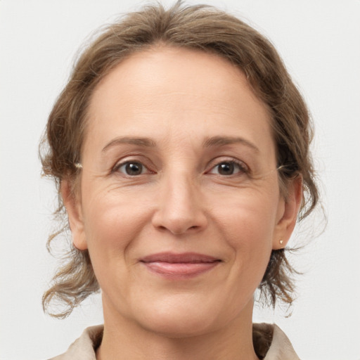 Joyful white adult female with medium  brown hair and grey eyes