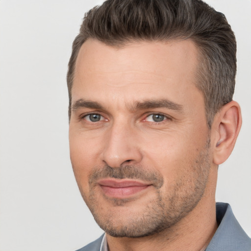 Joyful white adult male with short  brown hair and brown eyes