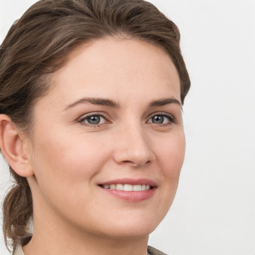 Joyful white young-adult female with short  brown hair and grey eyes