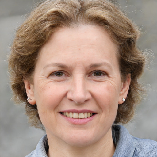 Joyful white adult female with medium  brown hair and blue eyes