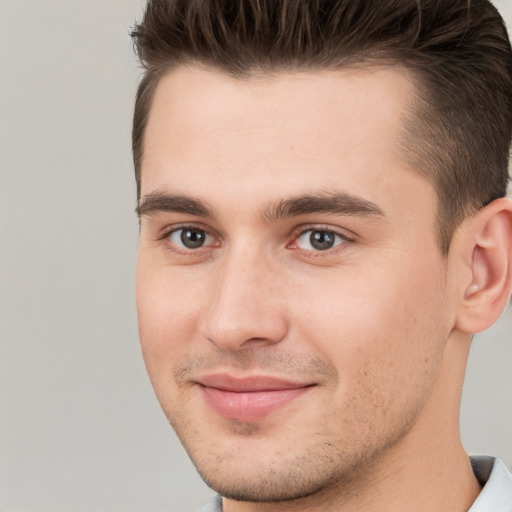 Joyful white young-adult male with short  brown hair and brown eyes