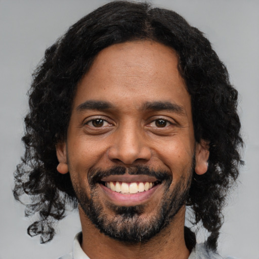 Joyful black young-adult male with medium  black hair and brown eyes