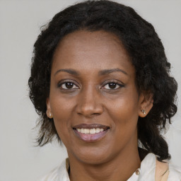 Joyful black adult female with medium  brown hair and brown eyes