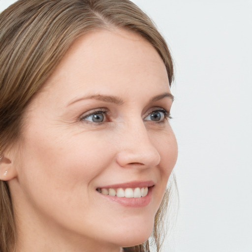 Joyful white young-adult female with long  brown hair and blue eyes