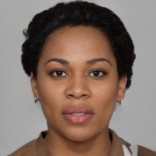 Joyful black young-adult female with short  black hair and brown eyes
