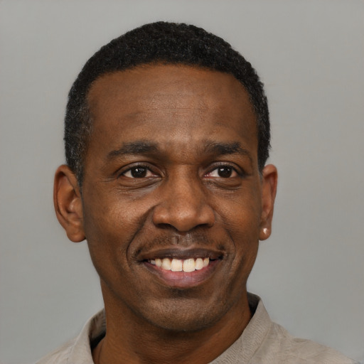 Joyful black young-adult male with short  black hair and brown eyes