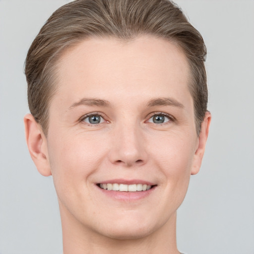 Joyful white young-adult female with short  brown hair and grey eyes