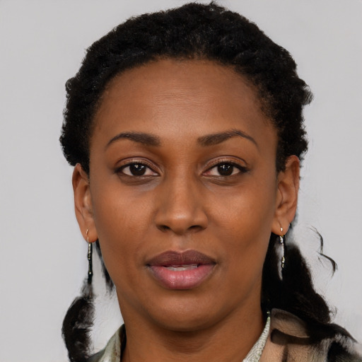 Joyful black young-adult female with short  black hair and brown eyes