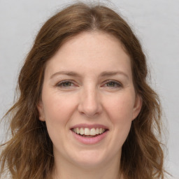 Joyful white adult female with long  brown hair and grey eyes