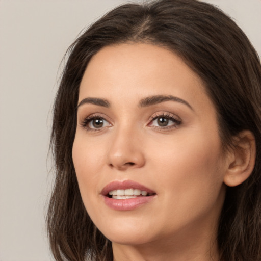 Joyful white young-adult female with long  brown hair and brown eyes