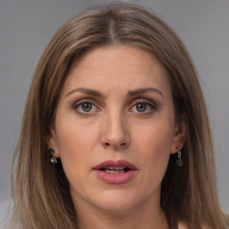 Joyful white adult female with long  brown hair and grey eyes