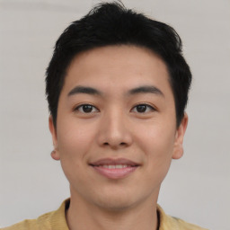 Joyful asian young-adult male with short  black hair and brown eyes