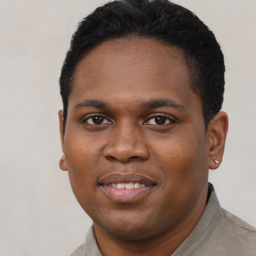 Joyful black young-adult male with short  brown hair and brown eyes