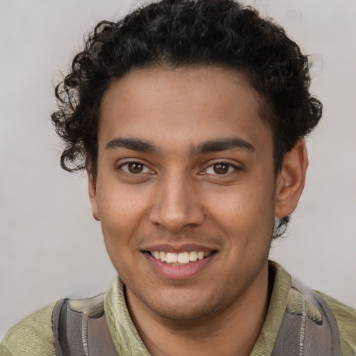 Joyful latino young-adult male with short  brown hair and brown eyes