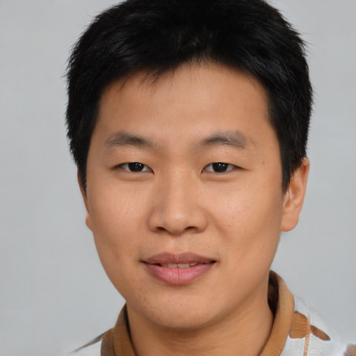 Joyful asian young-adult male with short  brown hair and brown eyes
