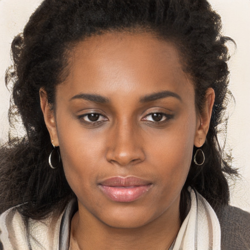 Joyful black young-adult female with long  brown hair and brown eyes