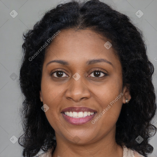 Joyful black young-adult female with long  brown hair and brown eyes