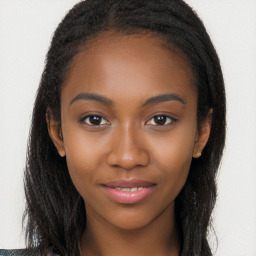 Joyful black young-adult female with long  brown hair and brown eyes