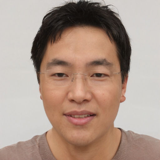 Joyful asian adult male with short  brown hair and brown eyes
