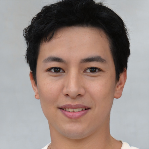 Joyful asian young-adult male with short  black hair and brown eyes