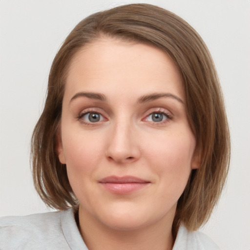 Joyful white young-adult female with medium  brown hair and blue eyes