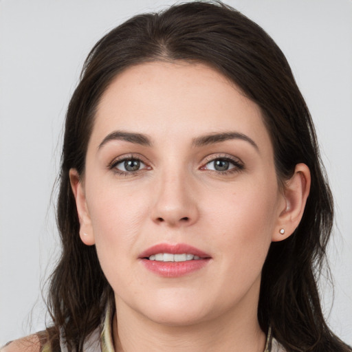 Joyful white young-adult female with long  brown hair and grey eyes