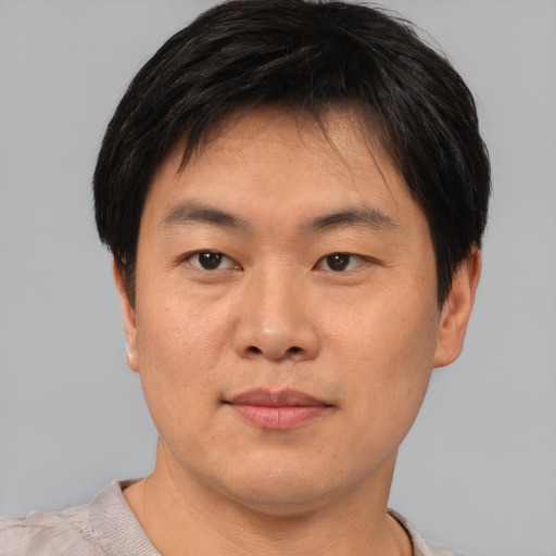 Joyful asian young-adult male with short  brown hair and brown eyes