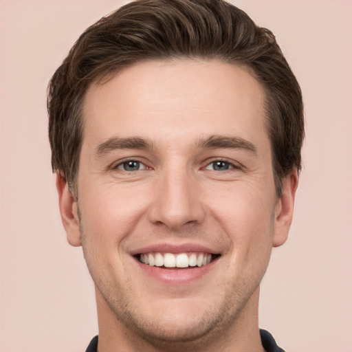 Joyful white young-adult male with short  brown hair and grey eyes