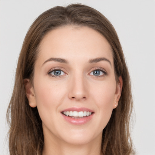 Joyful white young-adult female with long  brown hair and grey eyes