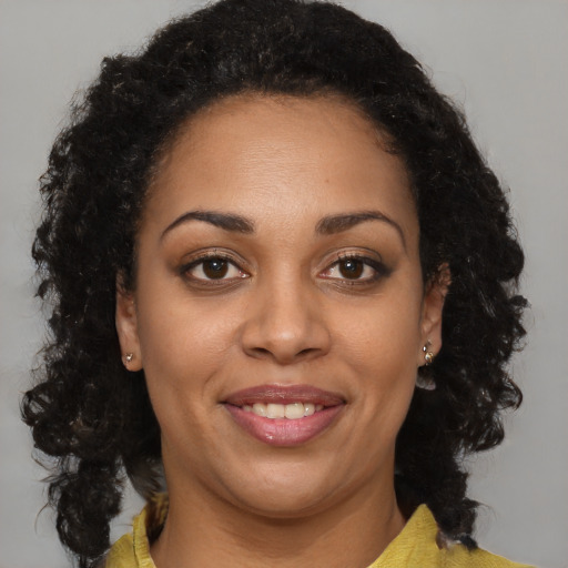 Joyful black adult female with medium  brown hair and brown eyes