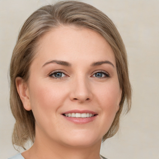 Joyful white young-adult female with medium  brown hair and green eyes