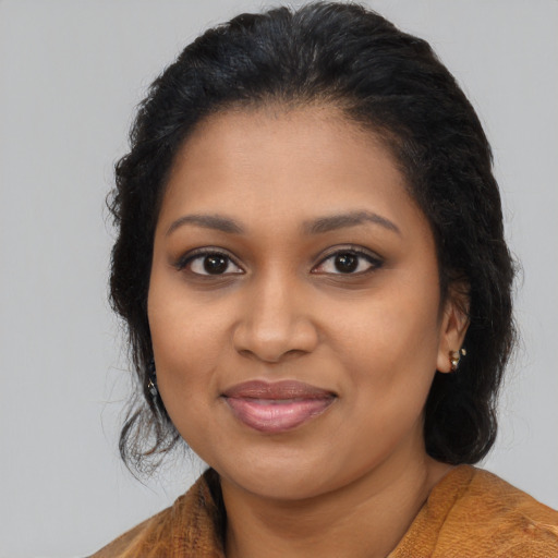 Joyful black young-adult female with long  brown hair and brown eyes