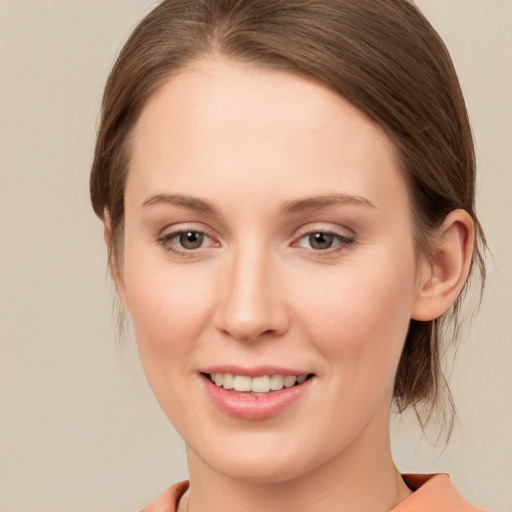 Joyful white young-adult female with medium  brown hair and green eyes