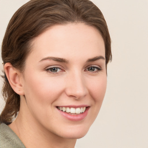 Joyful white young-adult female with medium  brown hair and grey eyes