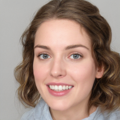 Joyful white young-adult female with medium  brown hair and blue eyes