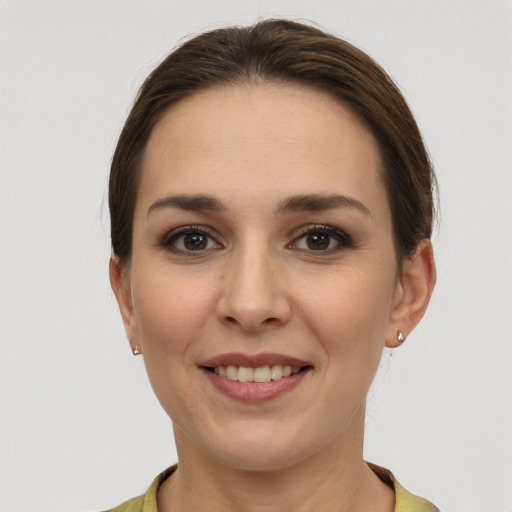 Joyful white young-adult female with short  brown hair and grey eyes