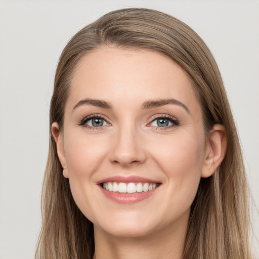 Joyful white young-adult female with long  brown hair and grey eyes