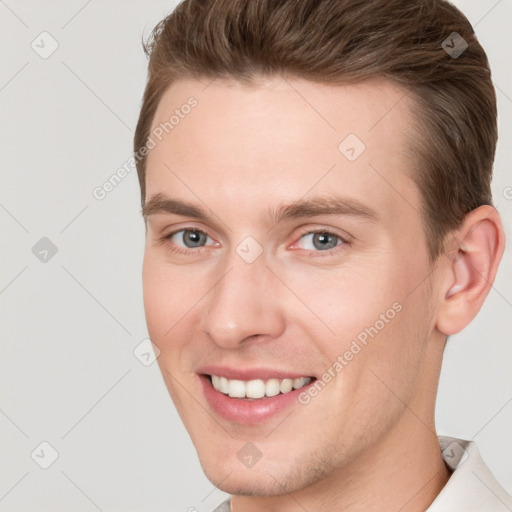 Joyful white young-adult male with short  brown hair and grey eyes