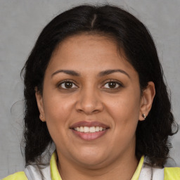 Joyful latino adult female with medium  brown hair and brown eyes