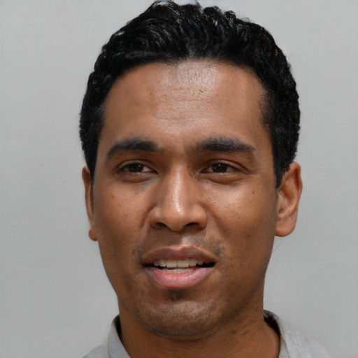 Joyful latino young-adult male with short  black hair and brown eyes