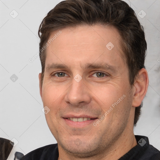 Joyful white adult male with short  brown hair and brown eyes