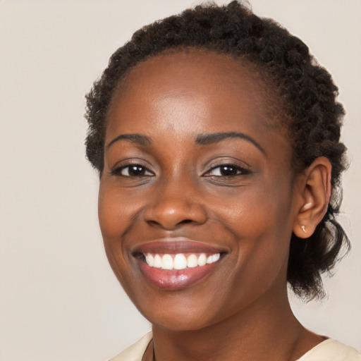 Joyful black young-adult female with long  brown hair and brown eyes