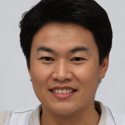 Joyful asian young-adult male with short  black hair and brown eyes