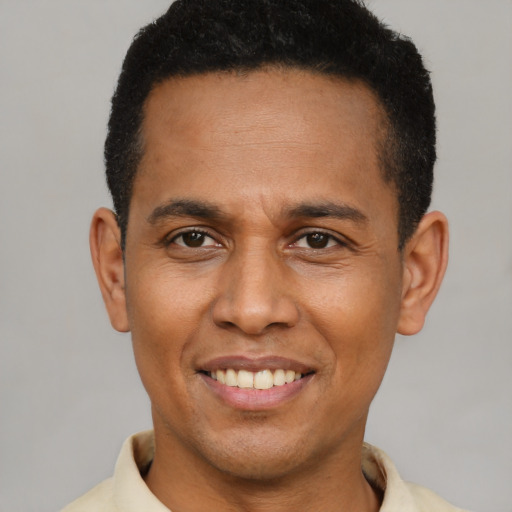 Joyful latino young-adult male with short  brown hair and brown eyes