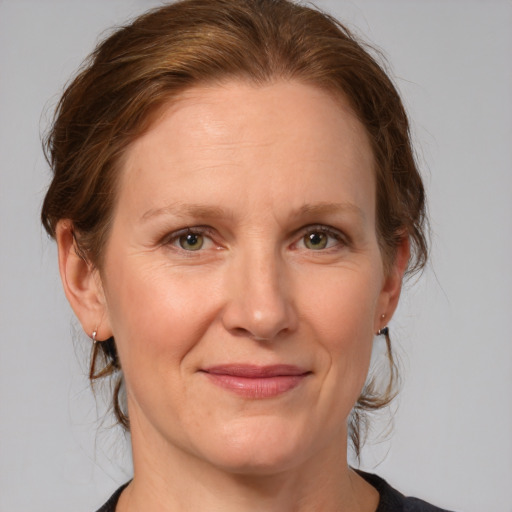 Joyful white adult female with medium  brown hair and grey eyes