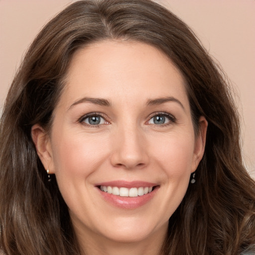 Joyful white young-adult female with long  brown hair and grey eyes